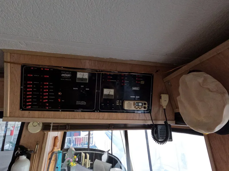 Slide: The Image of Control panel inside 1998 Jamestowner 1667WB Americana Custom houseboat, featuring gauges and communication equipment. - 32