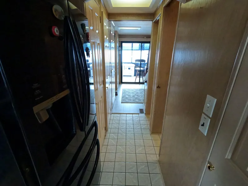 Slide: The Image of Interior hallway of 1998 Jamestowner 1667WB Americana Custom houseboat, featuring tiled floor and wooden cabinetry. - 41