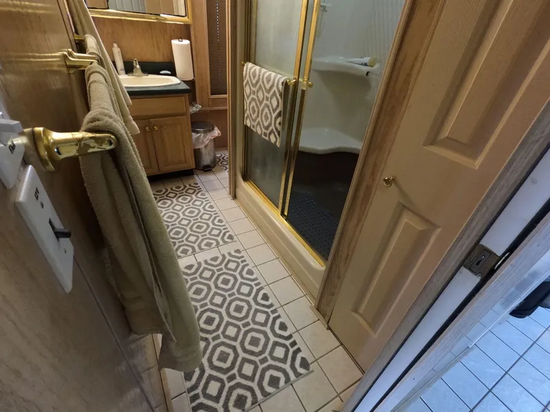 Slide: The Image of Bathroom interior of 1998 Jamestowner 1667WB Americana Custom with shower and patterned rugs. - 46