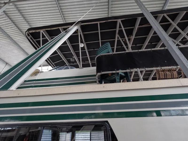 Slide: The Image of 1998 Jamestowner 1667WB Americana Custom houseboat with green and white exterior under a metal roof. - 9