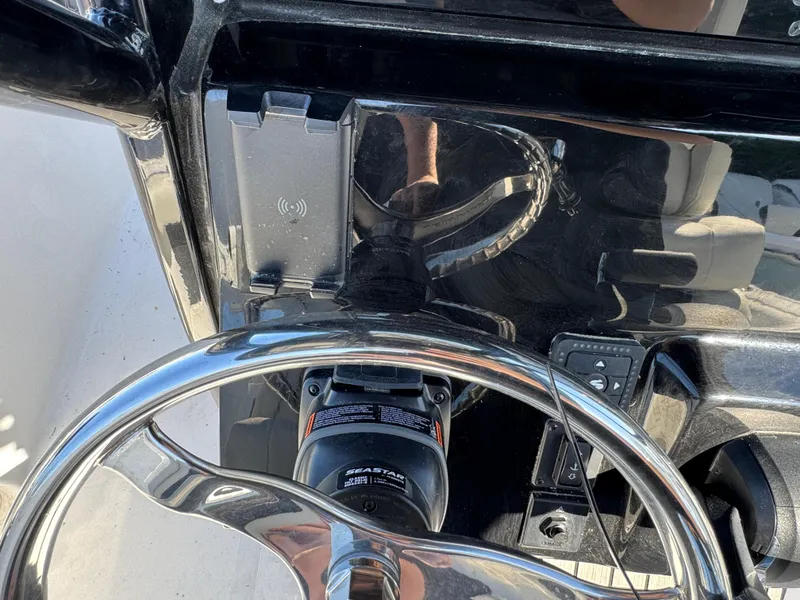 Slide: The Image of Steering wheel and dashboard of 2025 Tidewater 232 LXF boat, featuring modern controls. - 14