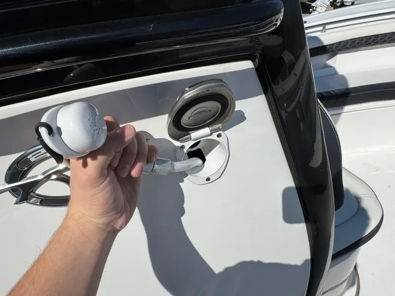 Slide: The Image of Hand holding a fuel nozzle near a 2025 Tidewater 232 LXF boat's fuel port. - 17