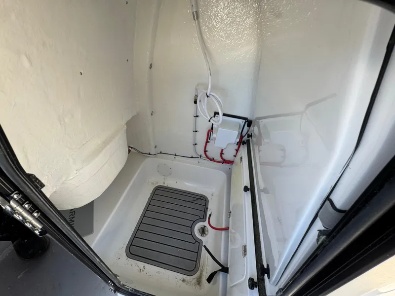 Slide: The Image of Interior view of 2025 Tidewater 232 LXF boat compartment with wiring and drainage. - 25