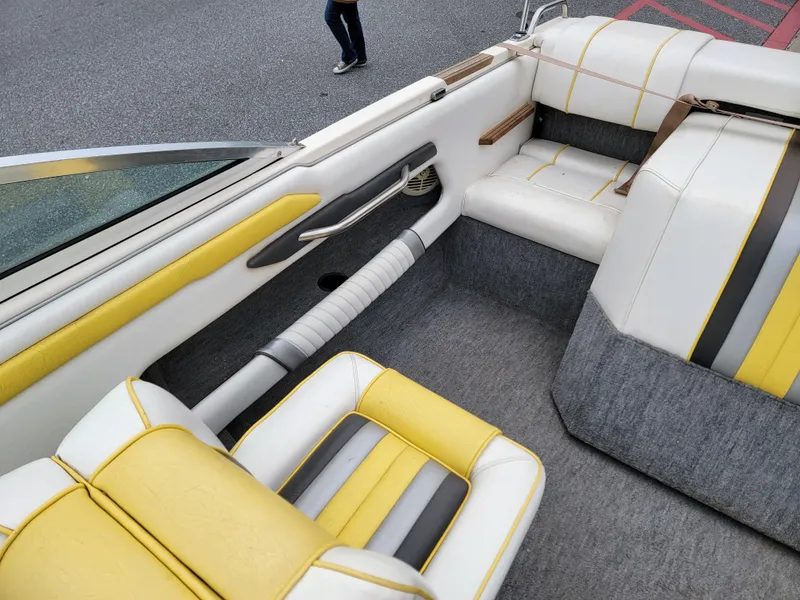 Slide: The Image of Interior of a 1990 Sea Ray 200 BR boat with yellow and gray seating. - 13