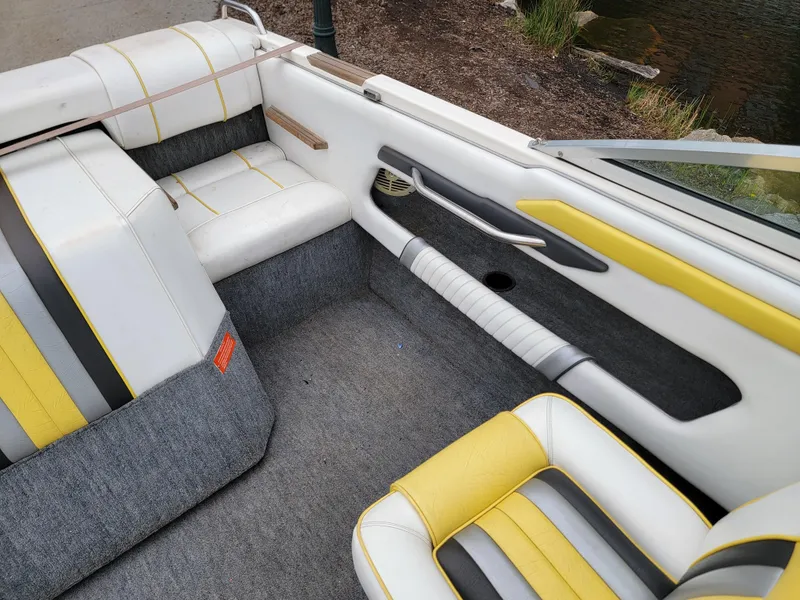 Slide: The Image of Interior of a 1990 Sea Ray 200 BR boat with yellow and gray seating. - 14