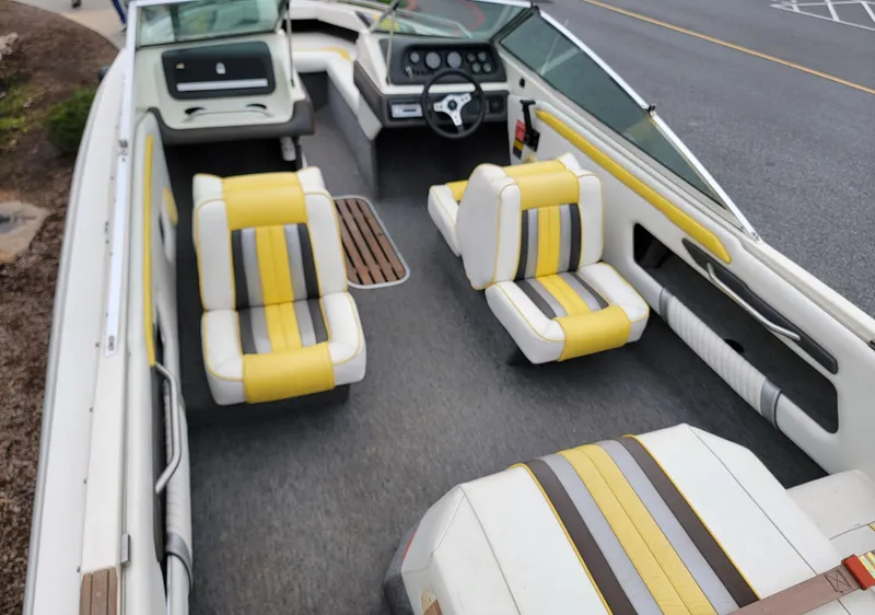 Slide: The Image of 1990 Sea Ray 200 BR boat interior with yellow-striped seats and steering console. - 15