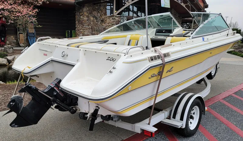 Slide: The Image of 1990 Sea Ray 200 BR boat on trailer, yellow and white design, parked outdoors. - 2