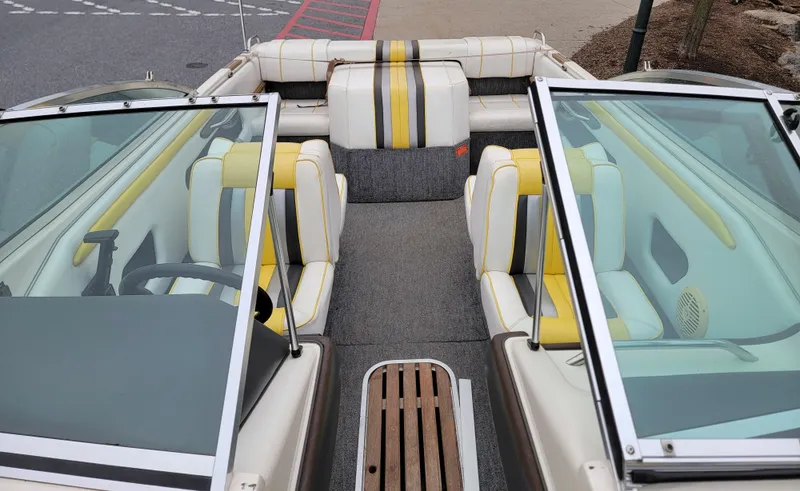 Slide: The Image of 1990 Sea Ray 200 BR boat interior with yellow and white seating, dual windshields, and steering wheel. - 6