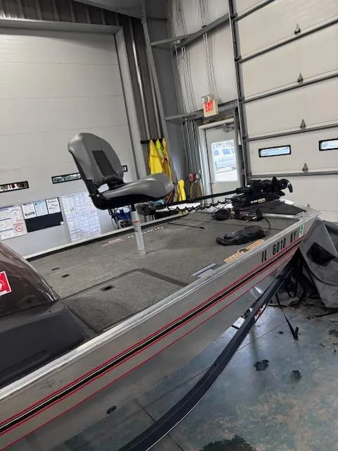 Slide: The Image of 2019 Bass Tracker Classic boat in a garage, featuring a mounted seat and equipment. - 2