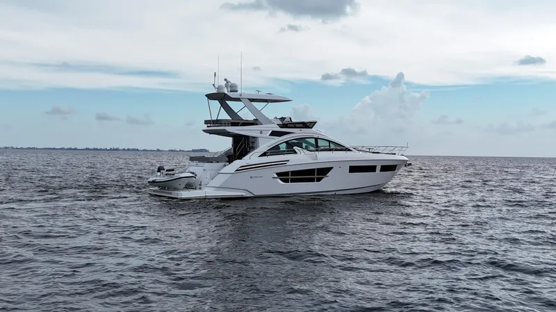 Slide: The Image of 2021 Cruisers Yachts 60 Cantius on open water under cloudy sky. - 2