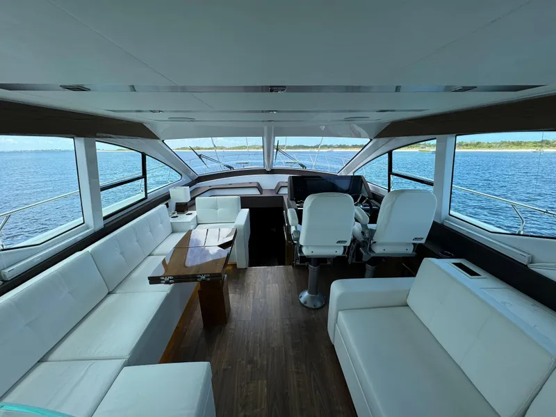 Slide: The Image of Luxurious interior of 2021 Cruisers Yachts 60 Cantius with white seating and panoramic windows. - 23