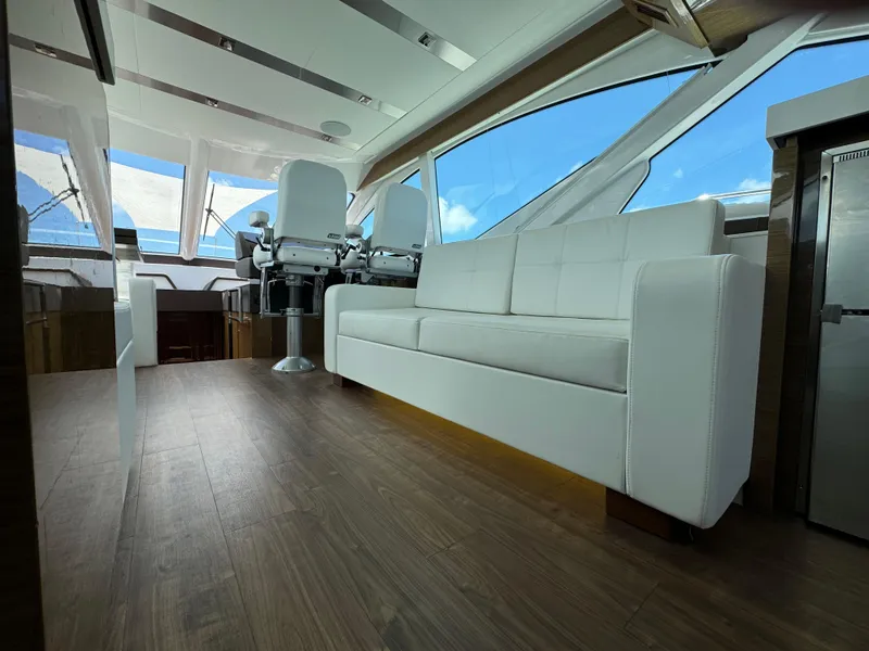 Slide: The Image of Luxurious interior of 2021 Cruisers Yachts 60 Cantius with white seating and panoramic windows. - 25