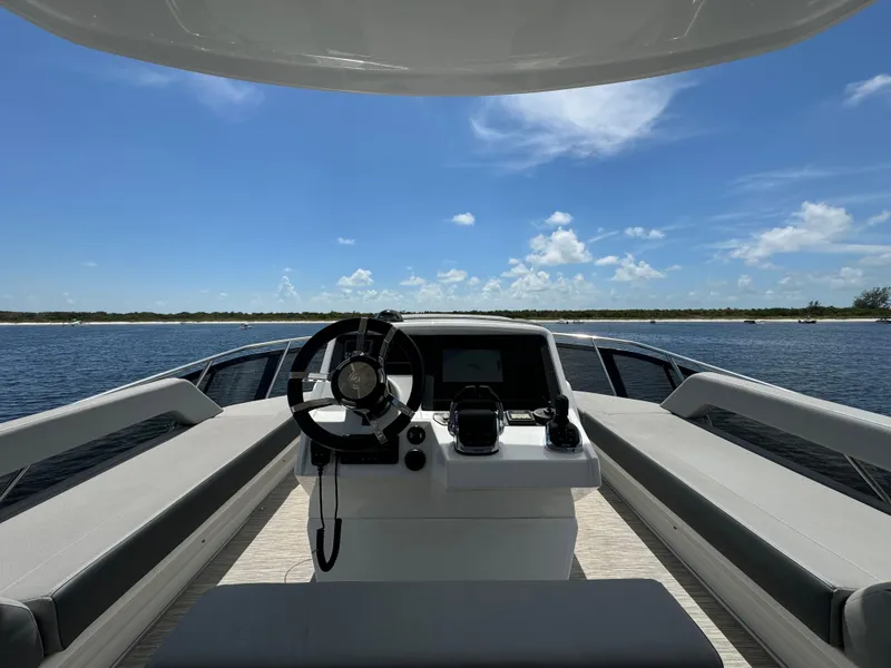 Slide: The Image of 2021 Cruisers Yachts 60 Cantius helm with panoramic water view under clear blue sky. - 39