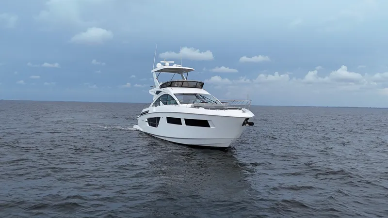 Slide: The Image of 2021 Cruisers Yachts 60 Cantius sailing on open water under a cloudy sky. - 4