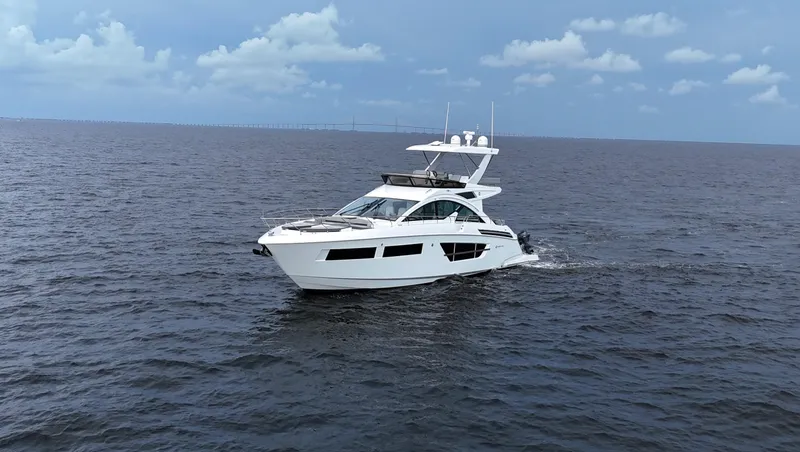 Slide: The Image of 2021 Cruisers Yachts 60 Cantius cruising on open water under a cloudy sky. - 6