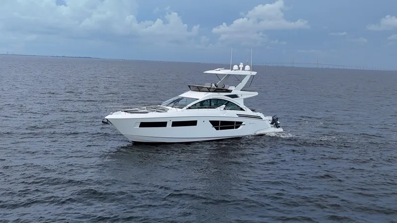 Slide: The Image of 2021 Cruisers Yachts 60 Cantius sailing on open water under a cloudy sky. - 7