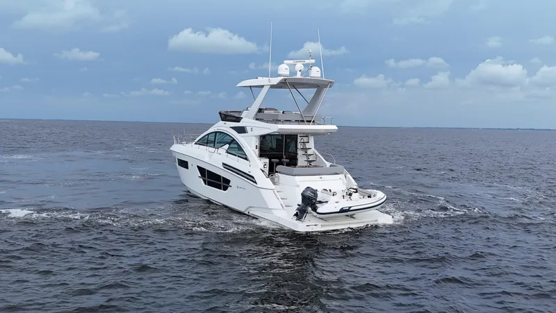 Slide: The Image of 2021 Cruisers Yachts 60 Cantius on open water under cloudy sky. - 8