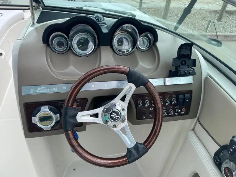 Slide: The Image of 2009 Sea Ray 260 Sundeck dashboard with gauges and steering wheel. - 17