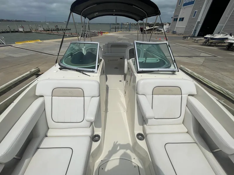 Slide: The Image of 2009 Sea Ray 260 Sundeck boat with white seating, docked near a marina. - 22