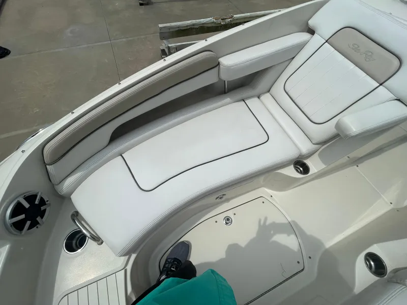Slide: The Image of 2009 Sea Ray 260 Sundeck boat interior with white cushioned seating and cup holders. - 23