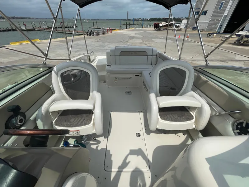 Slide: The Image of 2009 Sea Ray 260 Sundeck boat interior with seating, docked by the waterfront. - 27