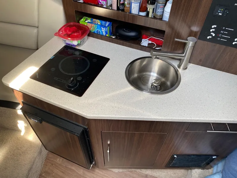 Slide: The Image of Compact kitchen area in a 2019 Regal 26 Express boat with sink and stove. - 10