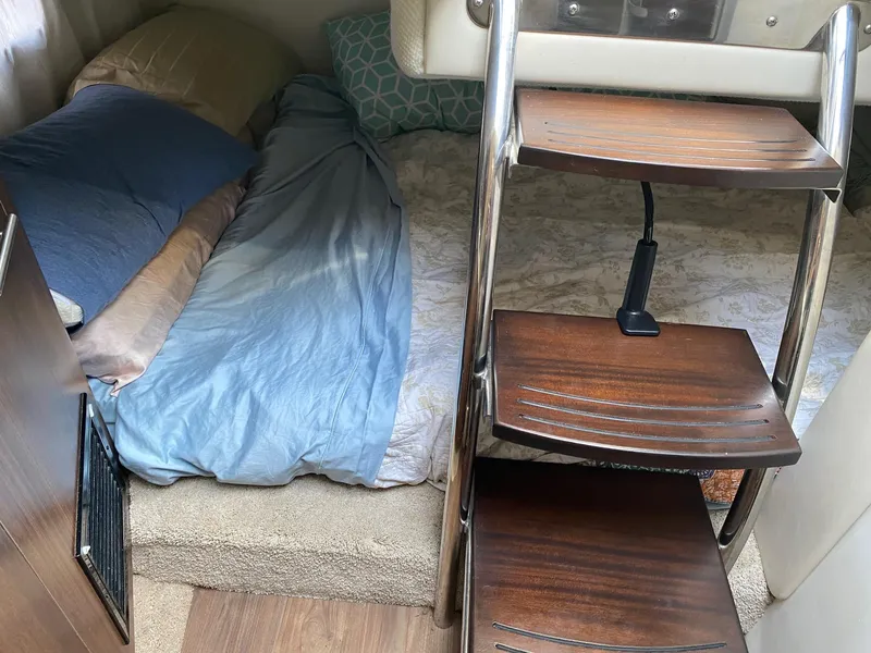 Slide: The Image of Cozy interior cabin of 2019 Regal 26 Express boat with wooden steps and bedding. - 15