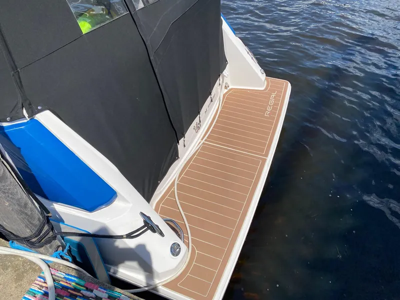 Slide: The Image of 2019 Regal 26 Express boat with swim platform on calm water. - 4
