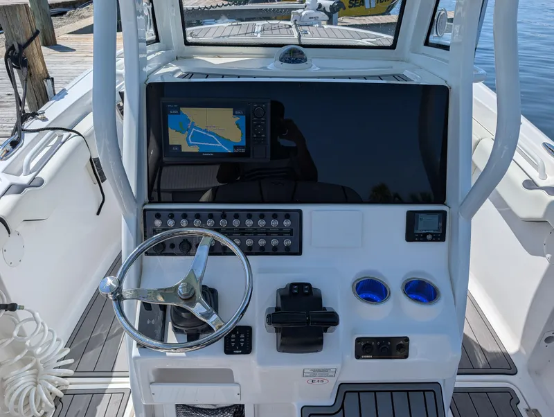 Slide: The Image of 2022 Tidewater 256 CC Adventure boat dashboard with navigation screen and controls. - 10