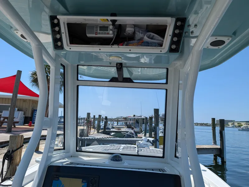 Slide: The Image of 2022 Tidewater 256 CC Adventure boat console with marina view in the background. - 11