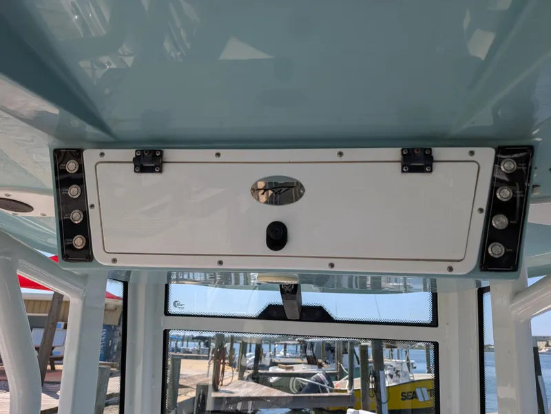 Slide: The Image of 2022 Tidewater 256 CC Adventure boat console with storage compartment and controls. - 17