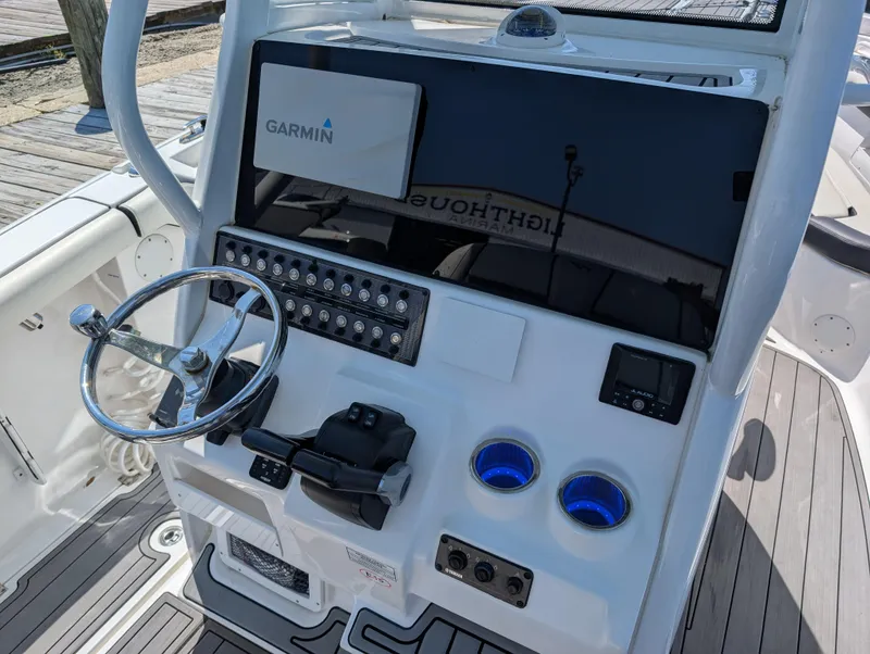 Slide: The Image of 2022 Tidewater 256 CC Adventure boat console with Garmin display and steering wheel. - 18