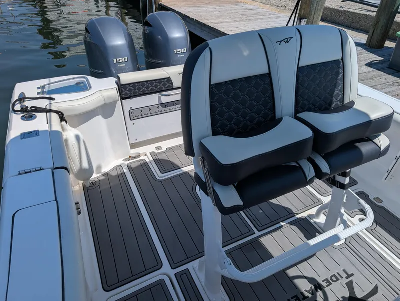 Slide: The Image of 2022 Tidewater 256 CC Adventure boat interior with dual seats and twin 150 engines. - 23