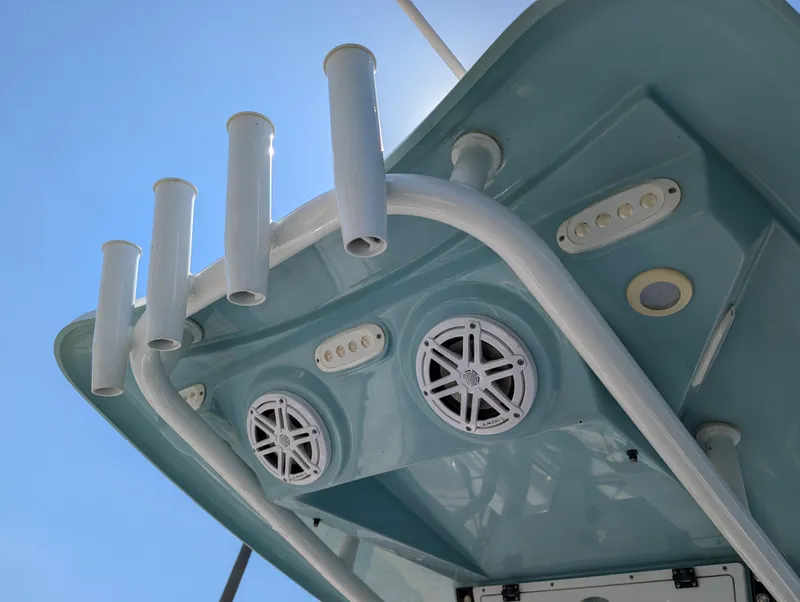 Slide: The Image of 2022 Tidewater 256 CC Adventure boat with rod holders and speakers on the underside of the T-top. - 28