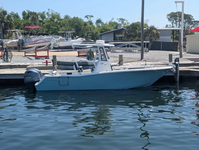 Slide: The Image of 2022 Tidewater 256 CC Adventure boat docked at marina, calm water, sunny day. - 3