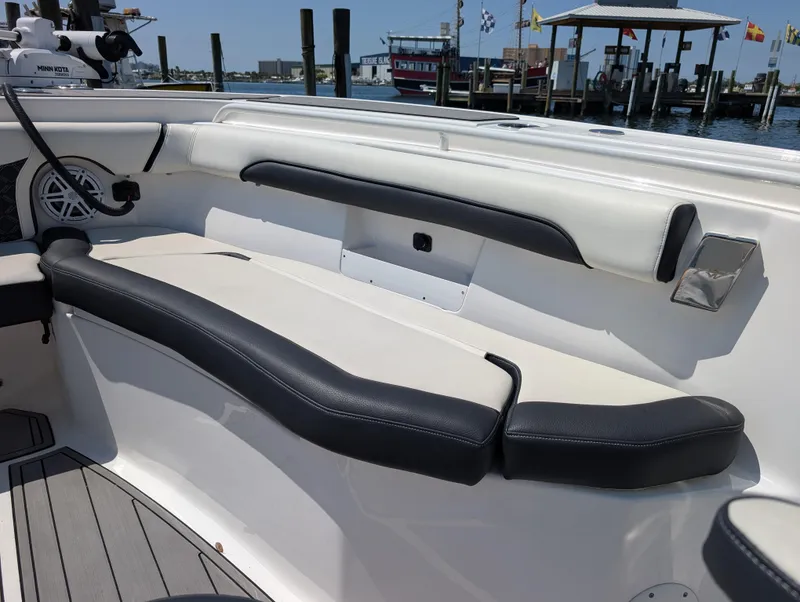Slide: The Image of 2022 Tidewater 256 CC Adventure boat interior with cushioned seating and harbor view. - 39