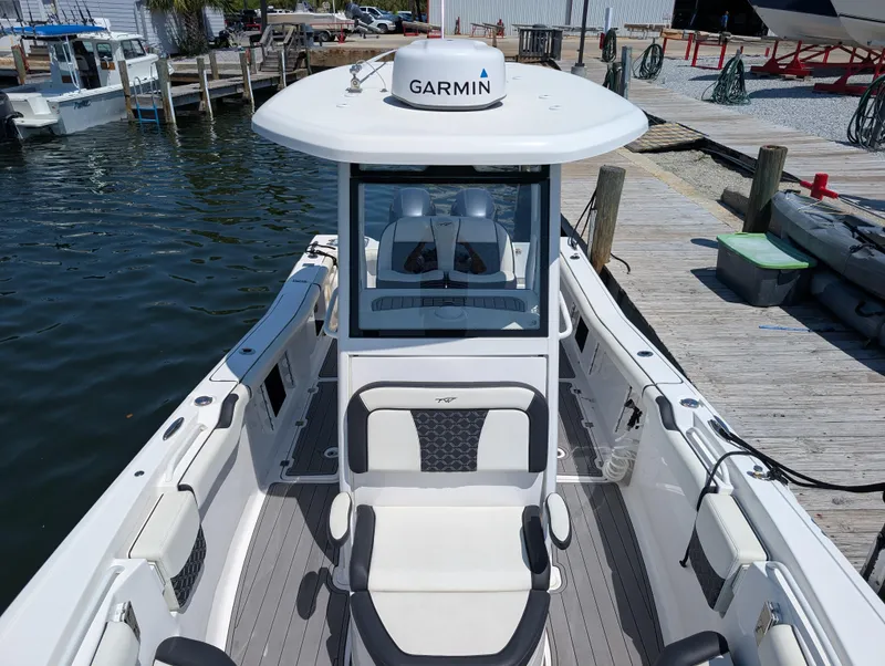 Slide: The Image of 2022 Tidewater 256 CC Adventure boat docked, featuring Garmin equipment and spacious seating. - 41