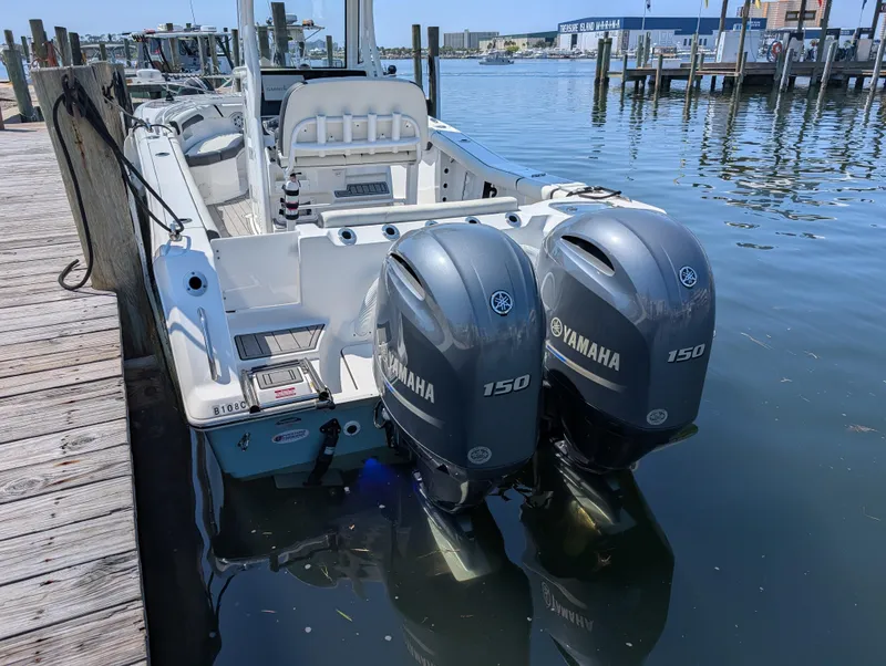 Slide: The Image of 2022 Tidewater 256 CC Adventure boat with twin Yamaha 150 engines docked at marina. - 8