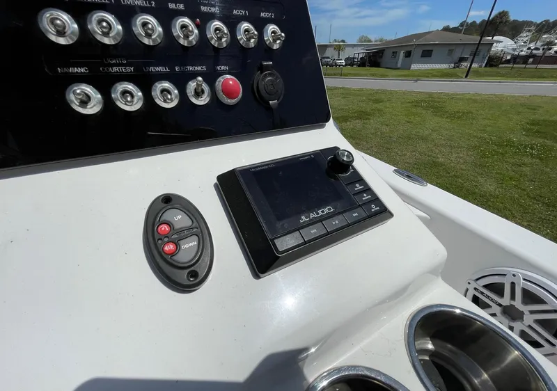 Slide: The Image of Control panel of a 2017 Sportsman Masters 207 Bay Boat with switches and a JL Audio system. - 15