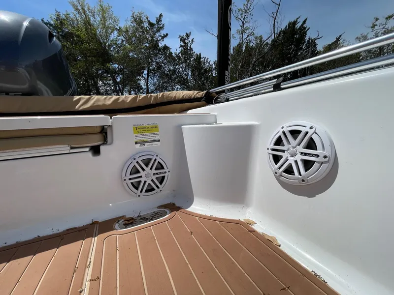 Slide: The Image of 2017 Sportsman Masters 207 Bay Boat interior with speakers and cushioned seating. - 19