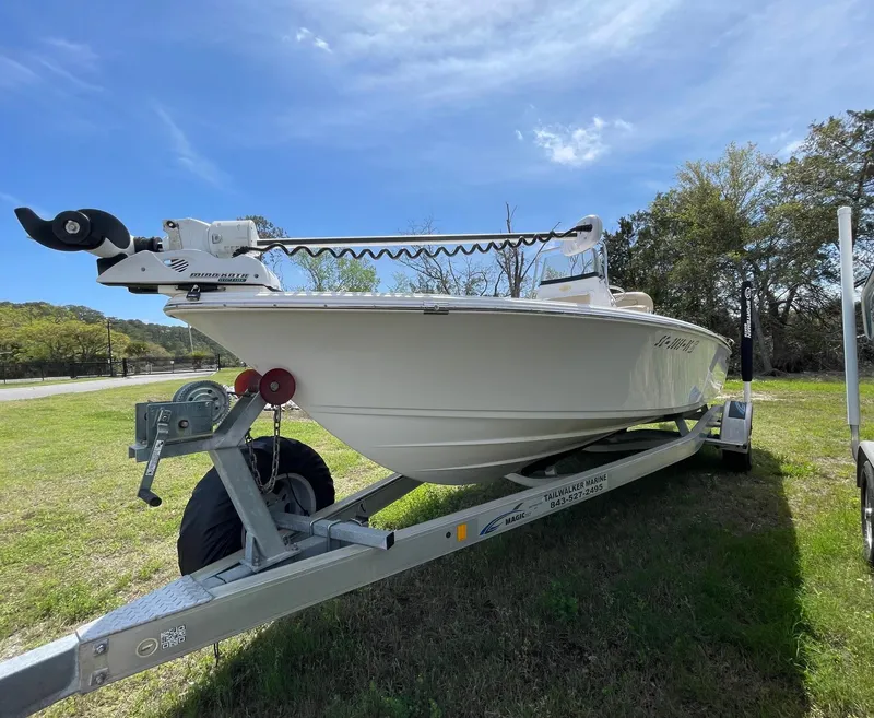 Slide: The Image of 2017 Sportsman Masters 207 Bay Boat on trailer, parked on grass under blue sky. - 2