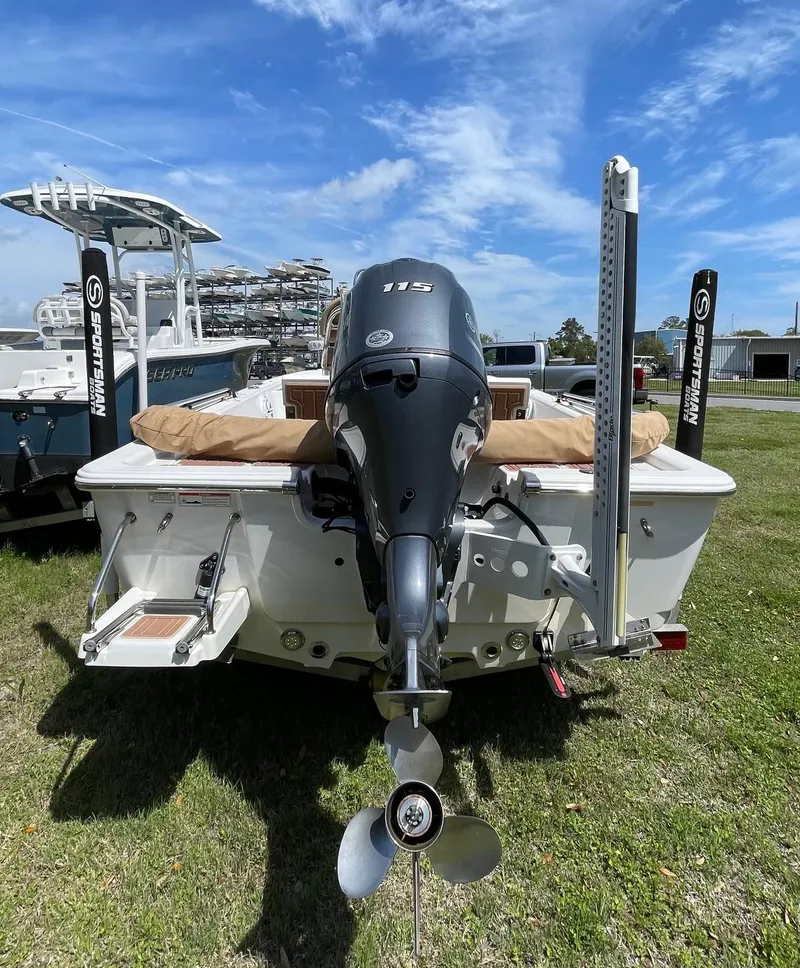 Slide: The Image of 2017 Sportsman Masters 207 Bay Boat with powerful outboard motor, parked on grass. - 4