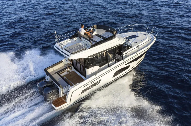 Slide: The Image of 2020 Jeanneau NC 1095 Fly cruising on open water, showcasing sleek design and powerful engines. - 2