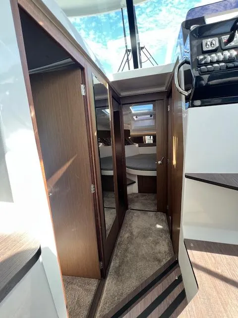 Slide: The Image of Interior view of 2020 Jeanneau NC 1095 Fly, featuring wood paneling and carpeted flooring. - 22