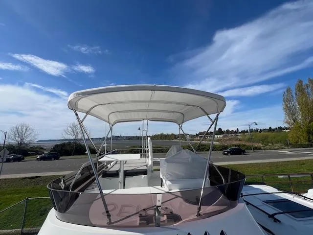 Slide: The Image of 2020 Jeanneau NC 1095 Fly yacht with canopy, parked near a scenic road. - 35