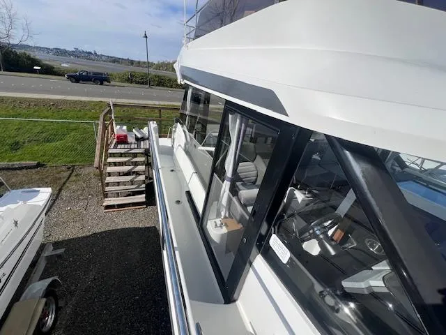 Slide: The Image of 2020 Jeanneau NC 1095 Fly boat docked, side view with windows and railing. - 37