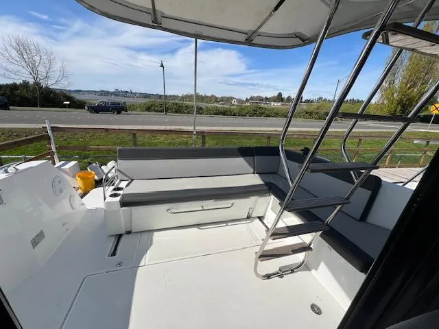 Slide: The Image of 2020 Jeanneau NC 1095 Fly boat deck with seating and ladder, near waterfront. - 40