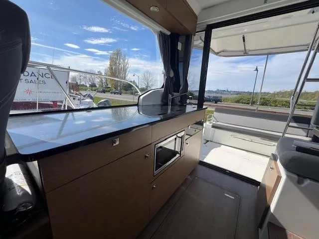 Slide: The Image of Interior view of 2020 Jeanneau NC 1095 Fly yacht with modern kitchen and outdoor seating. - 41
