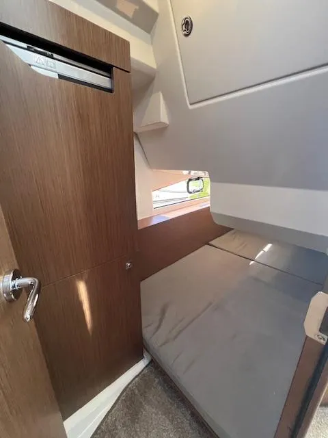Slide: The Image of 2020 Jeanneau NC 1095 Fly cabin interior with bed and wooden door. - 44