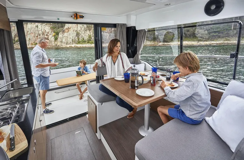 Slide: The Image of Family enjoying a meal on a 2020 Jeanneau NC 1095 Fly boat interior. - 8